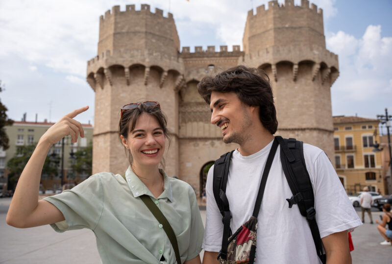 couple smiling in front of Serrano Towers in Valencia