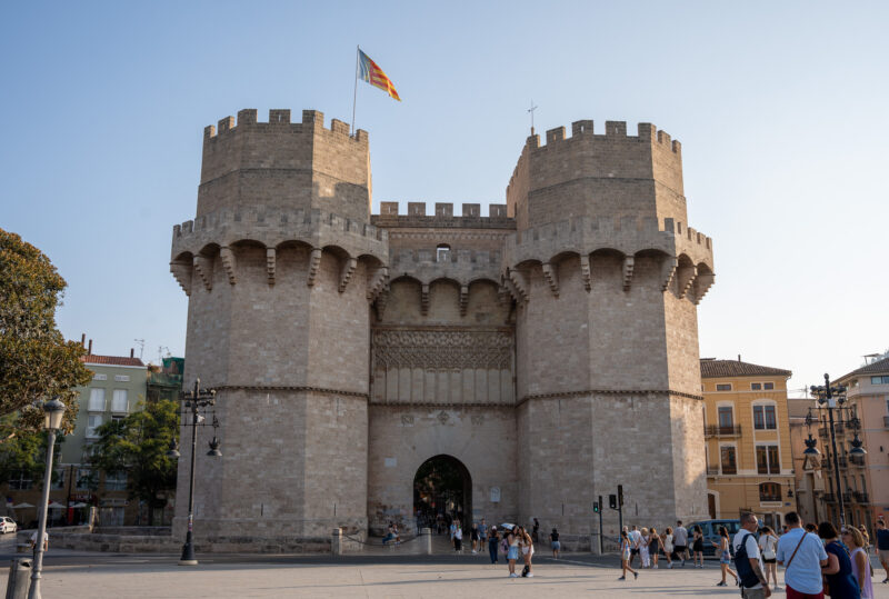 medieval building with two towers surrounded by tourists